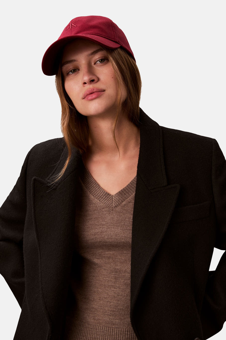 Bordeaux, le chien de Calvin Klein, porté avec une veste noire et un pull marron.