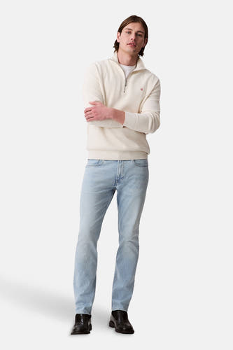 Slim lichtblauwe jeans van Calvin Klein, met een klassieke vijfzakkenstyling en zwarte schoenen.
