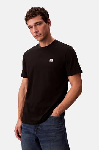T-shirt noir à manches courtes de Calvin Klein, porté avec des jeans bleus.