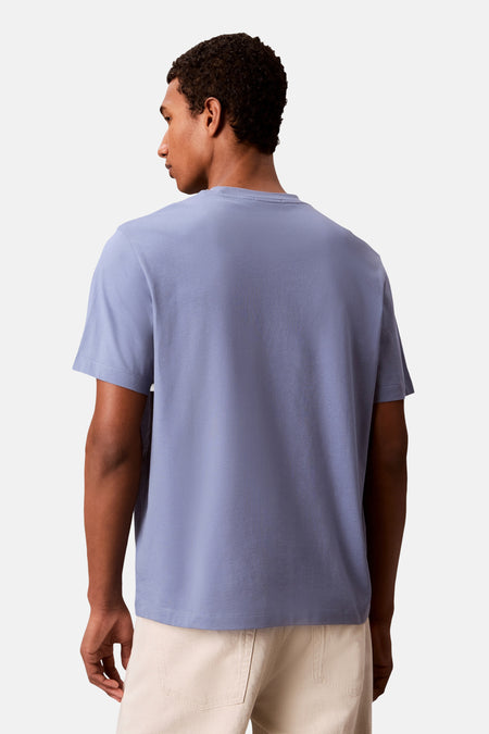 Lichtblauw T-shirt met korte mouwen van Calvin Klein, gedragen door een man, rugperspectief, met een beige broek.