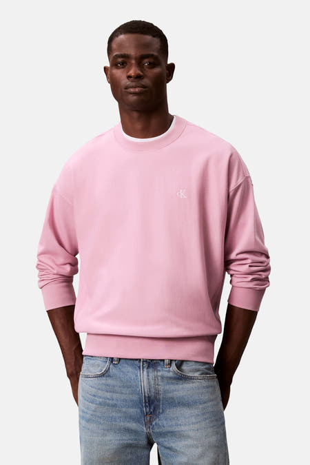 Roze sweater van Calvin Klein met een klein CK logo en gedragen met een spijkerbroek.

