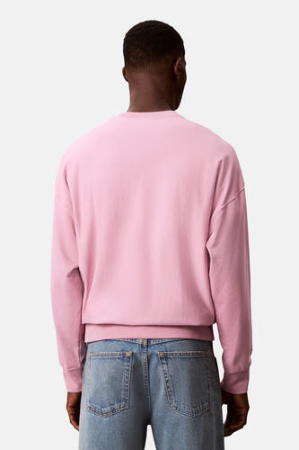 Roze sweater van Calvin Klein, gezien van achteren, met blauwe jeans.
