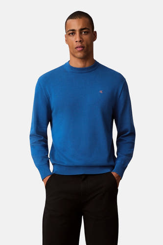 T-shirt bleu avec col rond de Calvin Klein, porté avec un pantalon noir.