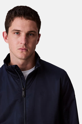 Blauwe regenjas van Calvin Klein, met ritssluiting en een klein CK-logo op de borst.