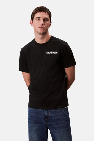 T-shirt noir à manches courtes de Calvin Klein, porté avec des jeans bleus.