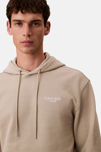 Gilet beige avec capuche de Calvin Klein Jeans, avec des cordons et le logo de la marque sur la poitrine.