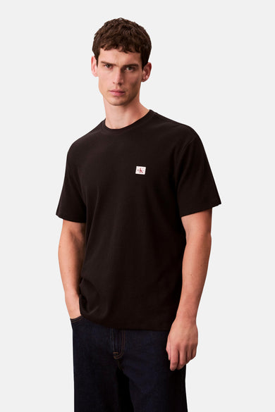Zwart T-shirt met korte mouwen van Calvin Klein, met een fijn wafelpatroon en een klein logo op de borst.