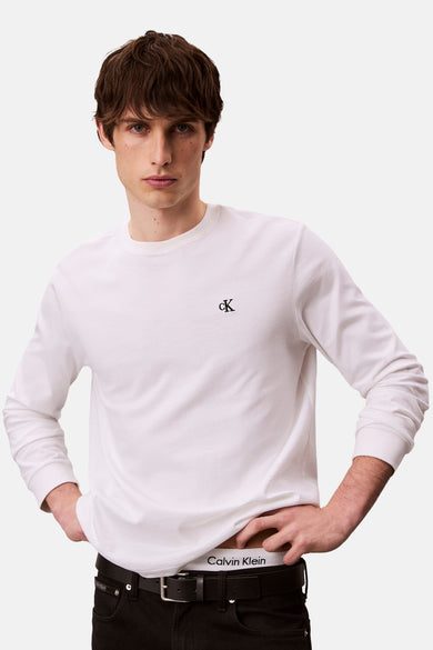 Wit T-shirt met lange mouwen van Calvin Klein, gedragen met een zwarte jeans en een witte onderbroek.
