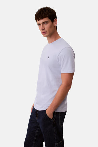 T-shirt bleu à manches courtes de Calvin Klein, porté avec des jeans foncés.
