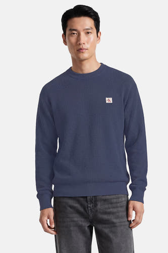 Blauwe ronde hals trui van Calvin Klein met textuur, klein logo op borst, front view, model draagt donkere jeans