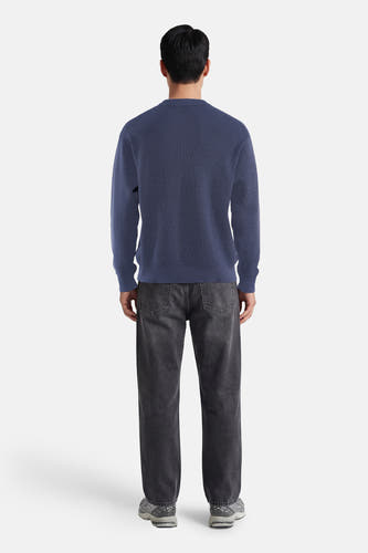 Blauwe ronde hals trui van Calvin Klein, achterzijde, fijn gebreid, gestreept patroon, gecombineerd met donkere jeans en sneakers