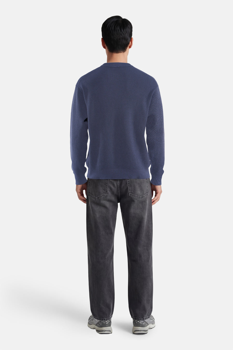 Blauwe ronde hals trui van Calvin Klein, achterzijde, fijn gebreid, gestreept patroon, gecombineerd met donkere jeans en sneakers
