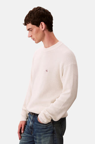 Sweat-shirt beige avec col rond de Calvin Klein, avec un logo subtil sur la poitrine et une texture rayée.