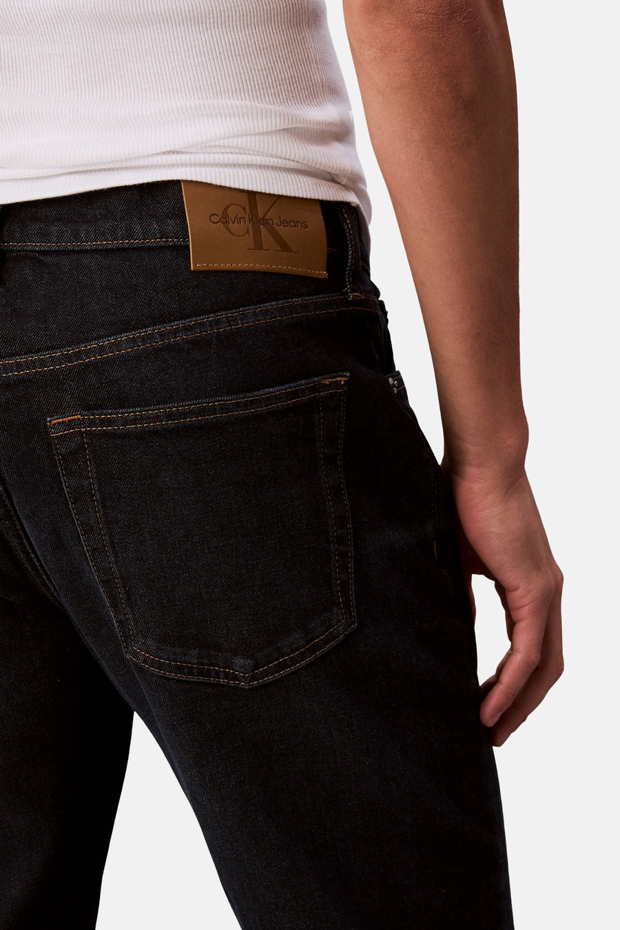 Jean tapered bleu marine de Calvin Klein Jeans, avec une étiquette en cuir sur l'arrière.