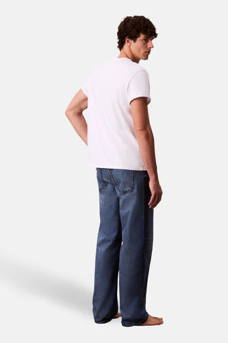 Jeans straight mid blue denim van Calvin Klein, met wijde pijpen en een casual uitstraling, gedragen met een wit T-shirt.