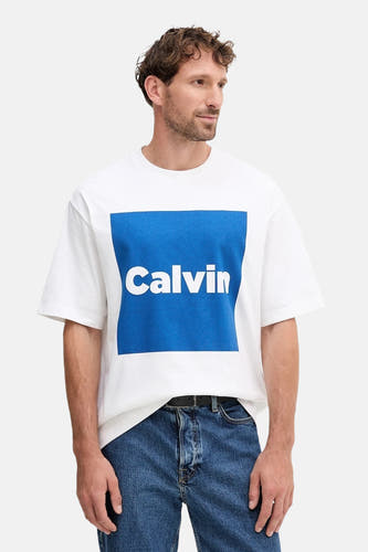 T-shirt blanc à manches courtes de Calvin Klein, porté avec des jeans et une ceinture.
