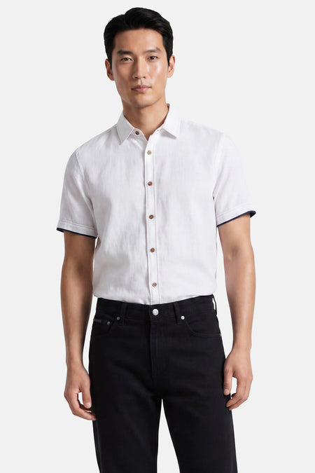 Jean droit noir de Calvin Klein, porté par un homme, avec bouton et rivets argentés.