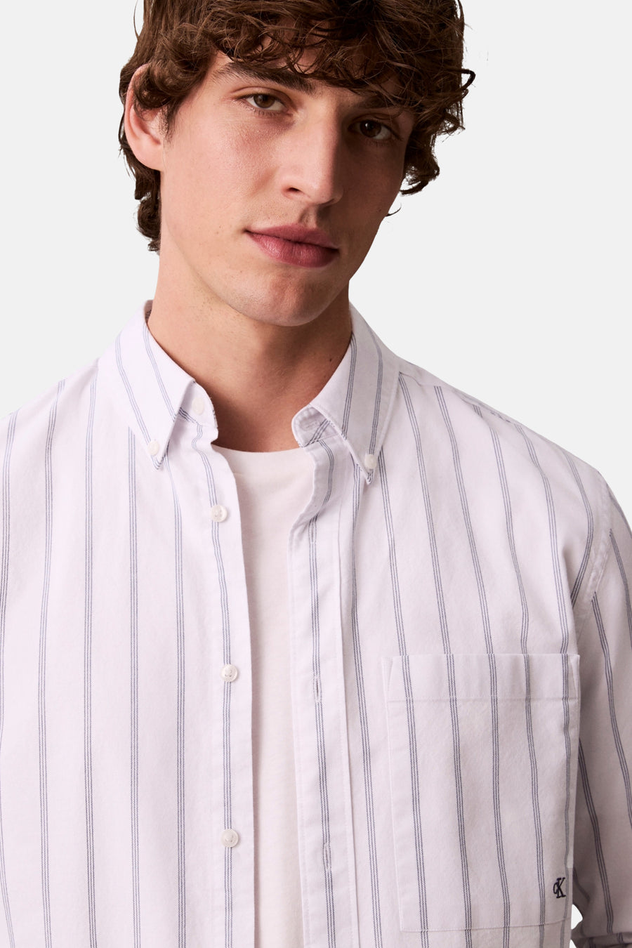 Wit overhemd met lange mouwen van Calvin Klein, met blauwe verticale strepen en borstzak.