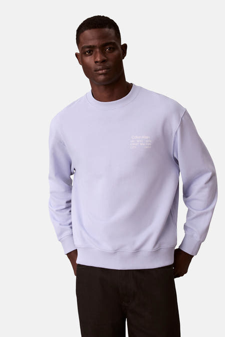 Paarse sweater met ronde hals van Calvin Klein, met tekstprint op de borst en zwarte broek.