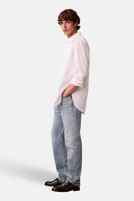 Rechte lichtblauwe jeans van Calvin Klein, met een nonchalante pasvorm en zwarte leren loafers.