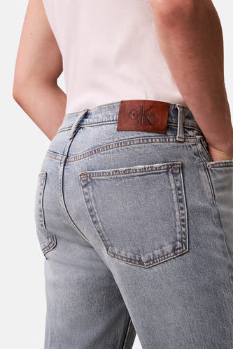 Jeans coupe droite en denim bleu clair de Calvin Klein, avec étiquette de marque en cuir marron à l'arrière.