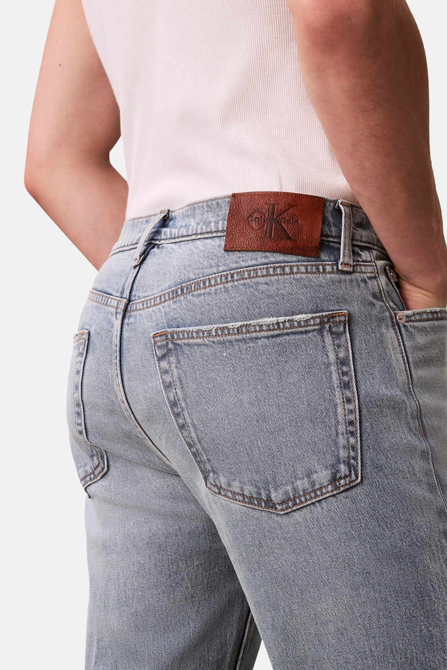 Jeans coupe droite en denim bleu clair de Calvin Klein, avec étiquette de marque en cuir marron à l'arrière.