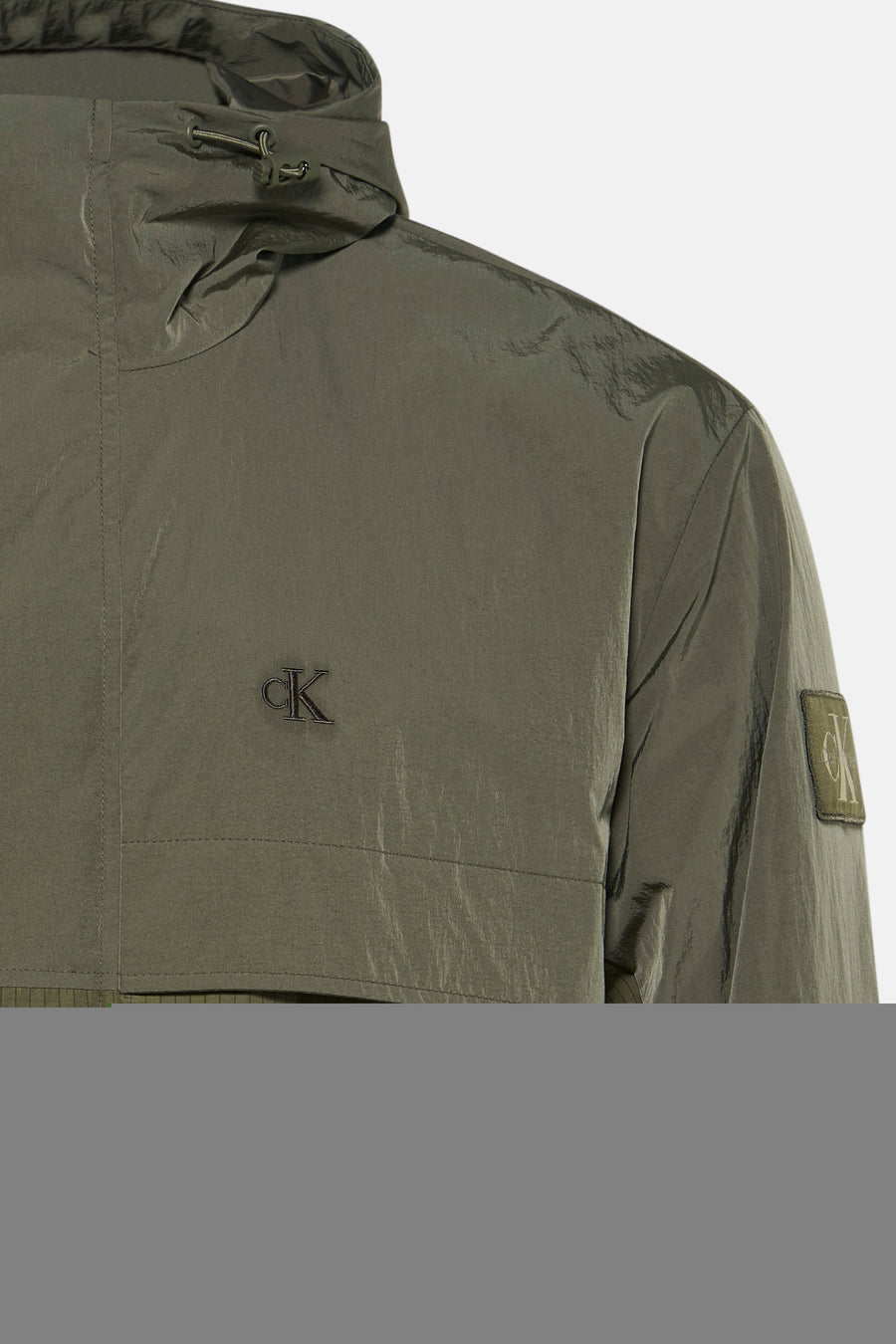 Kaki korte jas van Calvin Klein met capuchon, glanzend materiaal en CK-logo op borst en mouw, close-up zijaanzicht