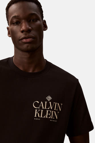 T-shirt noir à manches courtes de Calvin Klein, avec logo beige imprimé sur la poitrine.