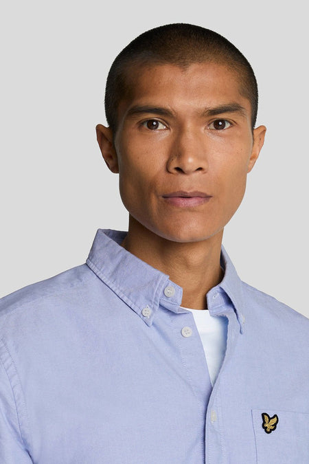 Lichtblauw overhemd met lange mouwen van LYLE & SCOTT, knoopsluiting en klein embleem op borstzakje, close-up voorzijde