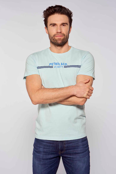 Lichtblauwe korte mouwen T-shirt van Petrol Industries® met blauw logo en strepen, gedragen door man met gekruiste armen, lifestyle shot