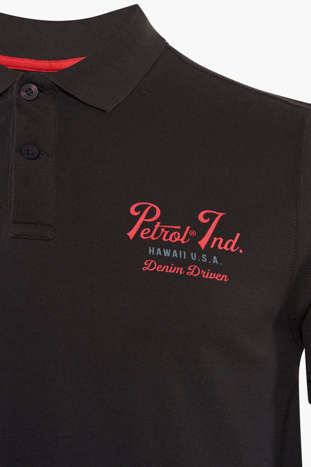 Zwart piqué poloshirt met rode details en geborduurde tekst.

