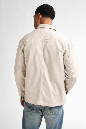 Man, achterkant, beige jas, blauwe jeans.