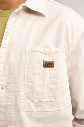 Chemise écru de Petrol Industries, avec une poche brodée et un étiquette de marque sur la poitrine.