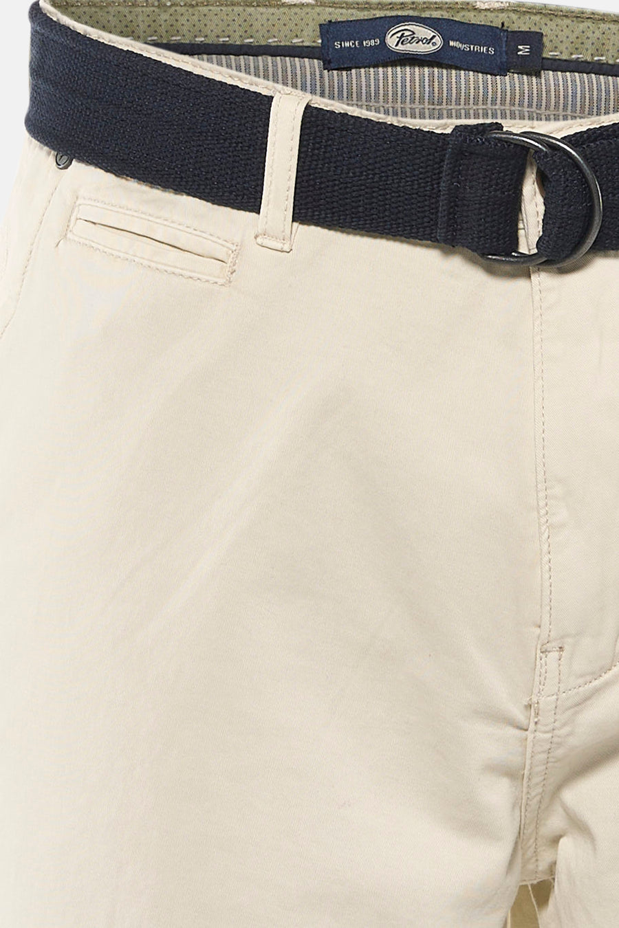Ecru short van Petrol Industries, met blauwe riem en steekzakken aan de voorkant, cropped.
