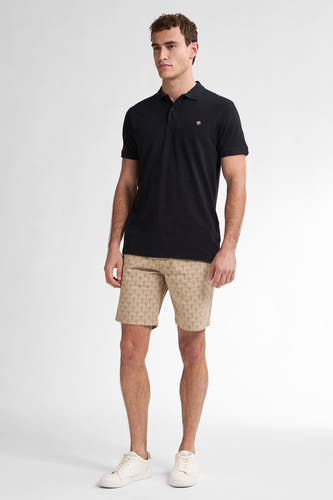 Beige short van Petrol Industries met een subtiel waaierpatroon, gecombineerd met een zwart poloshirt en witte sneakers.