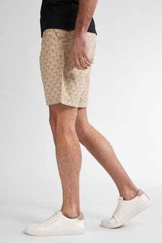 Beige short van Petrol Industries met waaierpatroon, gedragen met een zwart shirt en witte sneakers.