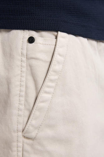 Beige korte broek van Petrol Industries® met een steekzak en een donkerblauw shirt.