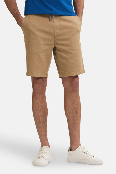 Pantalon court beige de Petrol Industries, avec cordon et sneakers blanches.