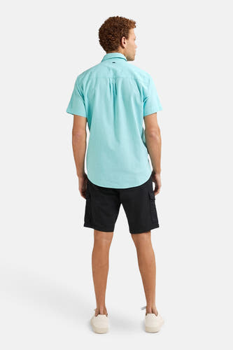 Turquoise overhemd met korte mouwen van Petrol Industries®, achterkant, gecombineerd met zwarte shorts en crèmekleurige schoenen.