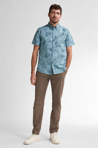 Blauw overhemd met korte mouwen van Petrol Industries, met bloemenprint en gecombineerd met bruine broek en witte sneakers.