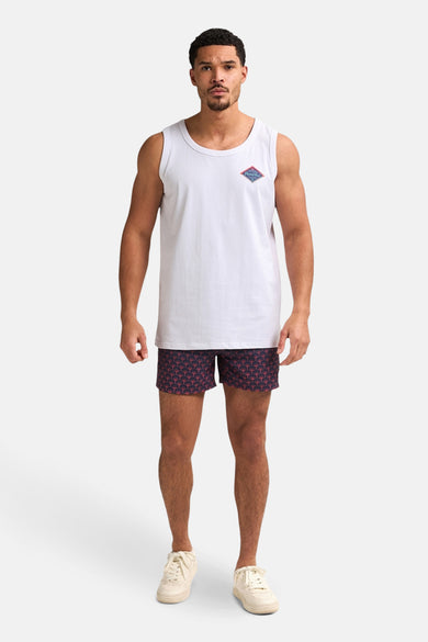 Blauwe zwemshort van Petrol Industries met een patroon en verder gecombineerd met een wit hemd en crèmekleurige schoenen.
