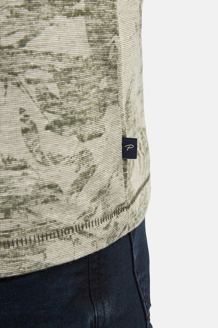 T-shirt vert avec manches courtes de Petrol Industries®, avec un motif de feuille sur toute la surface et une texture tissée, gros plan.