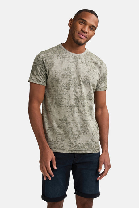 Groen T-shirt met korte mouwen van Petrol Industries®, met een all-over bladprint, gecombineerd met donkerblauwe denim shorts.