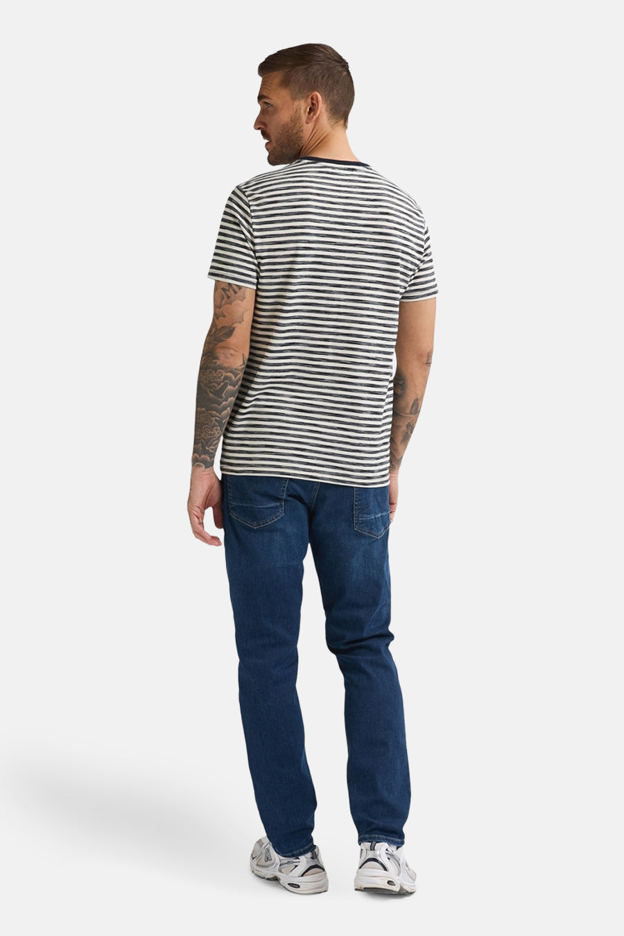 Man met gestreepte top en blauwe jeans.
