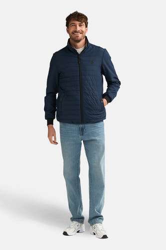 Kort blauw jack van Petrol Industries, met lange mouwen, gedragen met jeans en sneakers.
