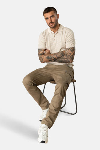 Ecru polo met korte mouwen van Petrol Industries®, met een subtiel ruitjespatroon, gedragen met kaki broek en witte sneakers.
