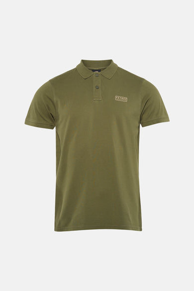 Polo verte de Petrol Industries à manches courtes avec un patch logo, combinée avec un jean bleu et des baskets blanches.