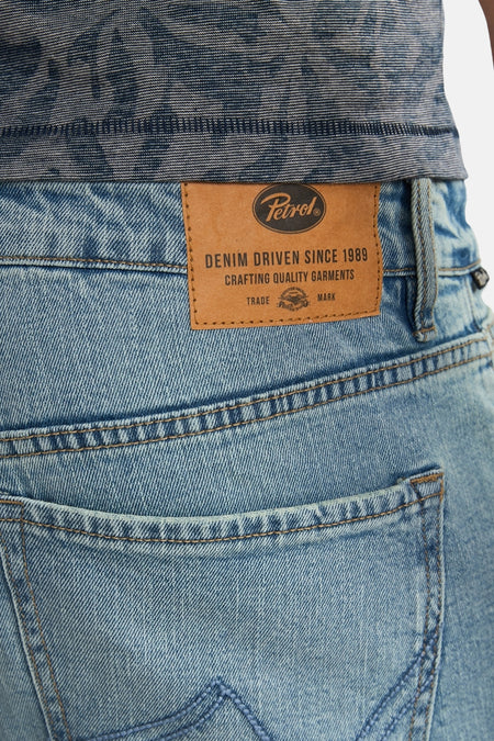 Short en jean bleu clair de Petrol Industries avec une texture denim et une étiquette de marque en cuir.