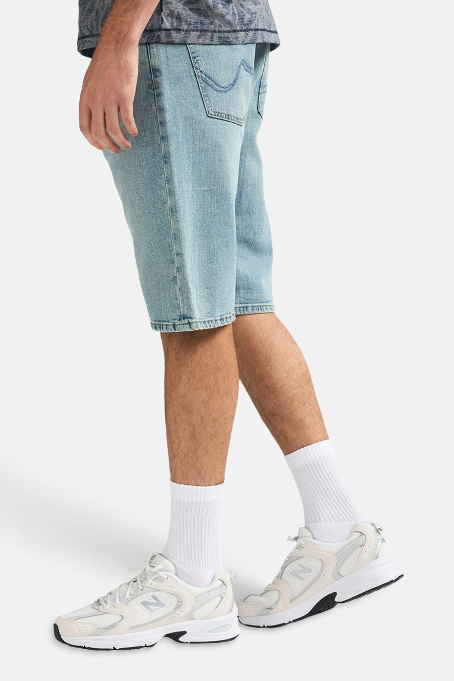 Short en jean en denim bleu clair de Petrol Industries®, avec chaussettes blanches et baskets.