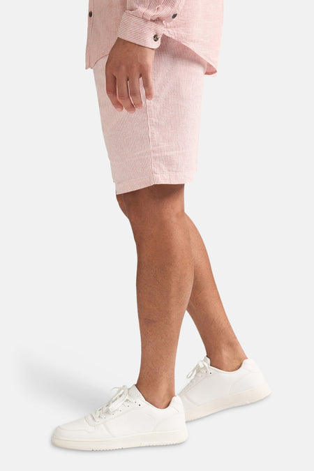 Roze gestreepte short van Petrol Industries, gedragen met een bijpassend overhemd en witte sneakers.